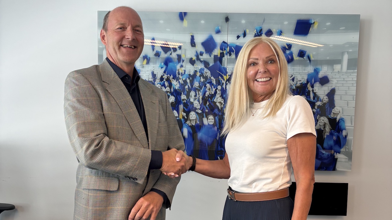Adm dir i Econa, Nina Riibe, og Marius Eriksen, Executive Vice President Business, Handelshøyskolen BI, tar hverandre i hånden over den nye samarbeidsavtalen.